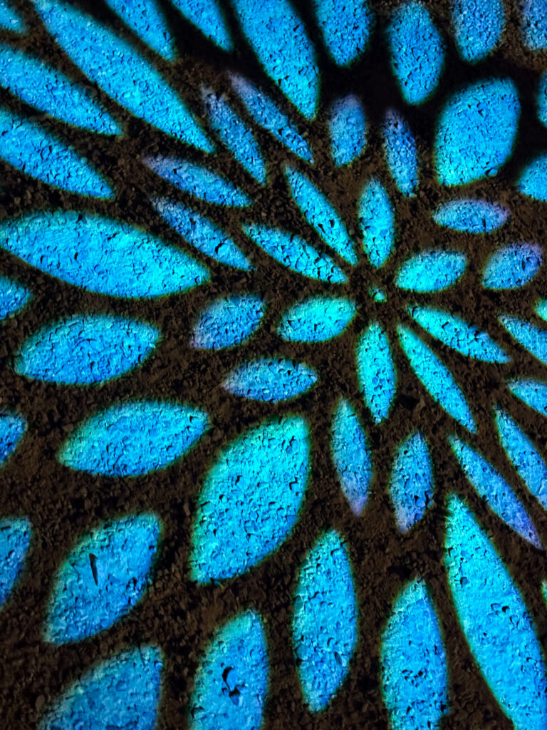 青い花模様が地面に広がる幻想的なライトアップ
Blue floral projection pattern lighting up the path