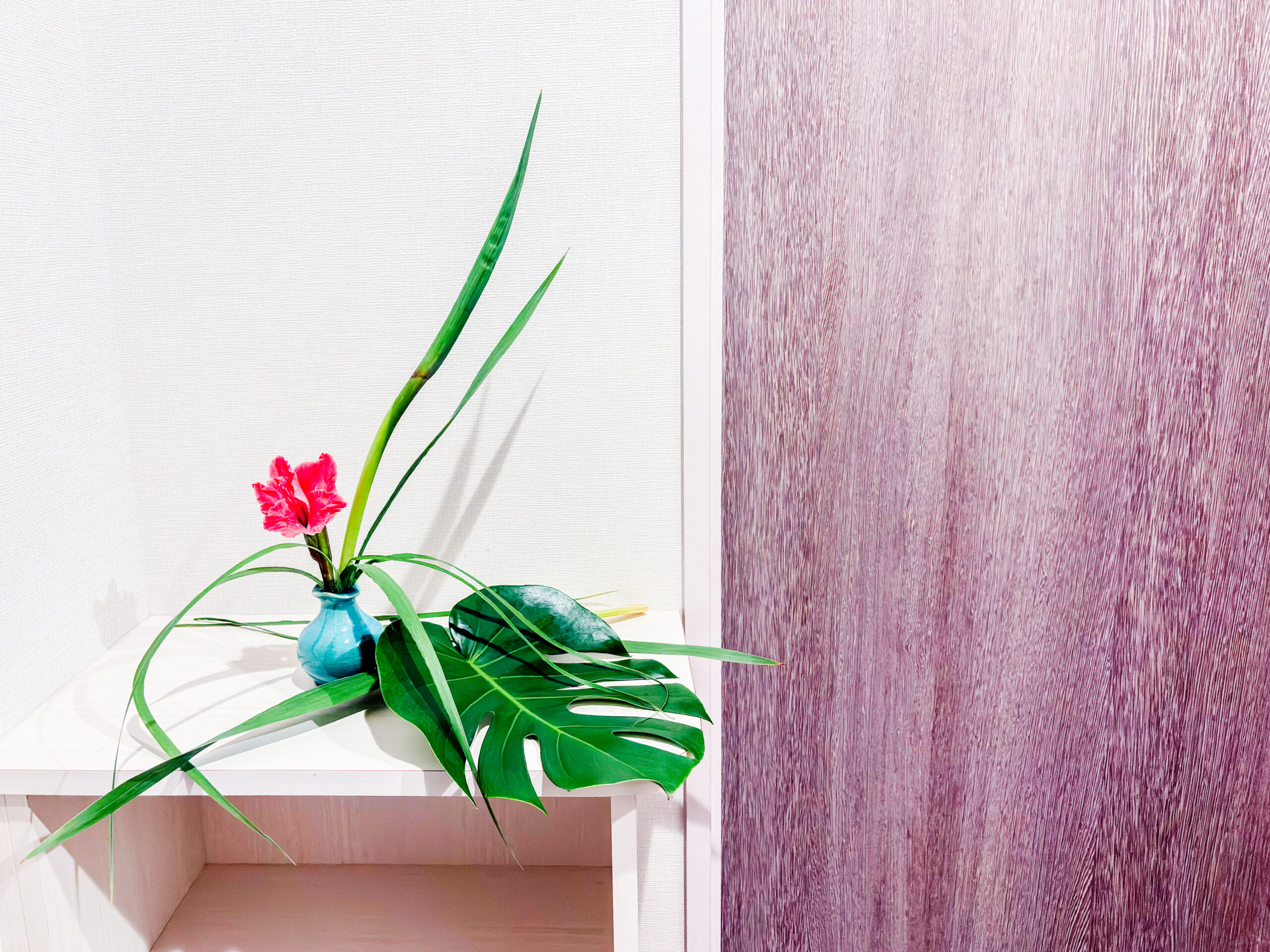 玄関に飾ったグラジオラスとモンステラの一輪挿しいけばな作品。
Entryway ikebana arrangement with gladiolus and monstera in a single-flower vase.