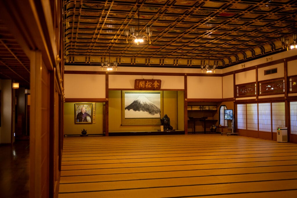 永平寺の大広間。格子模様の天井と広がる畳敷きが印象的な静寂の空間
