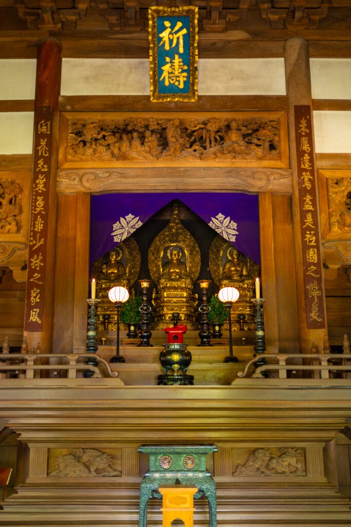 永平寺の本堂にある金色の仏像と祈祷の額。荘厳な雰囲気に包まれた祭壇
